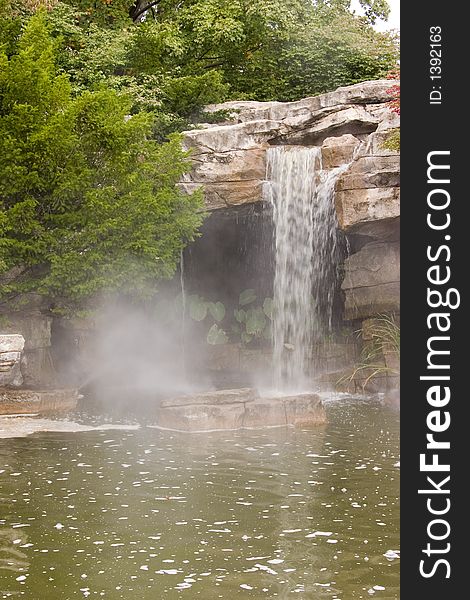 A small waterfall in a greenish colored lake. A small waterfall in a greenish colored lake.