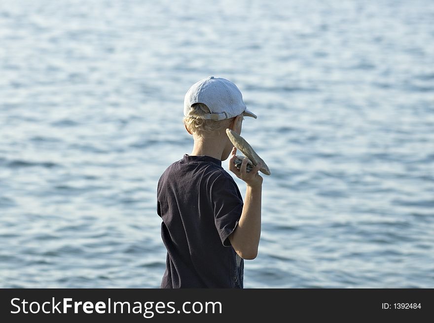 The child plays on a stone beach. The child plays on a stone beach