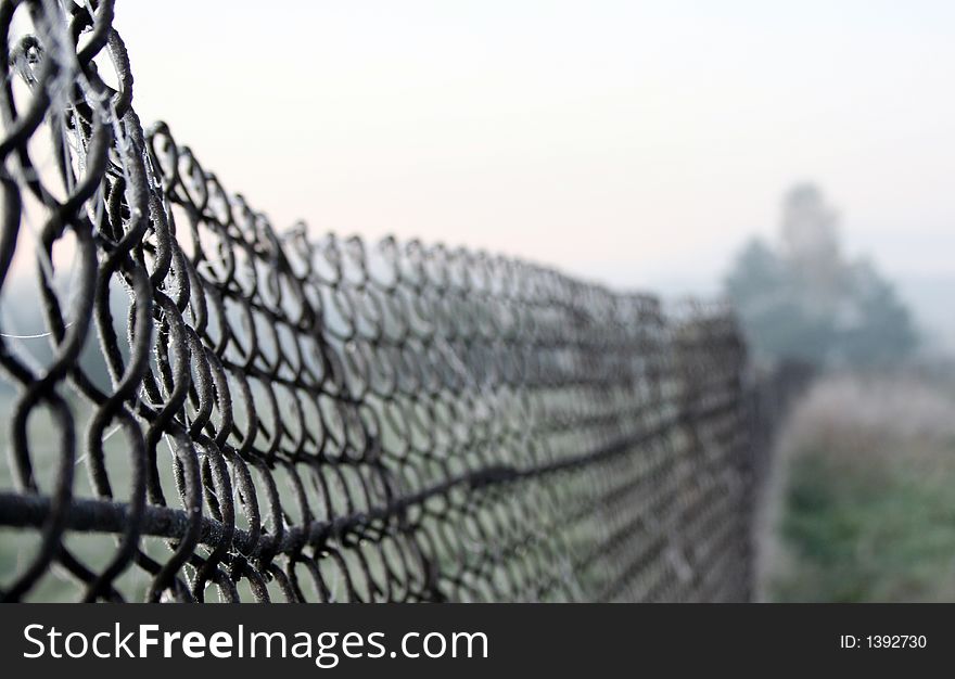 Metal net fence early in the morning with frost. Metal net fence early in the morning with frost