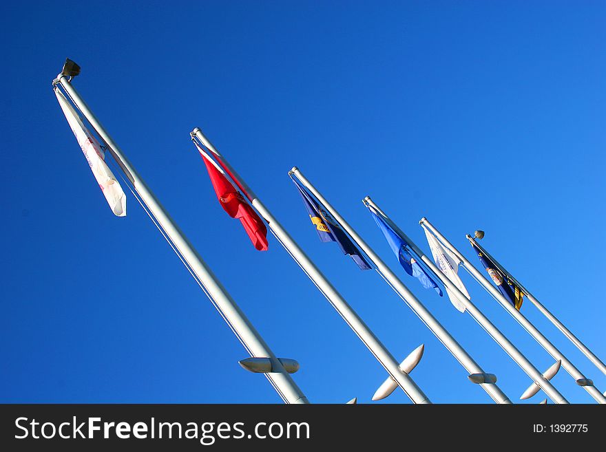 Colorful flags at angle against blue sky