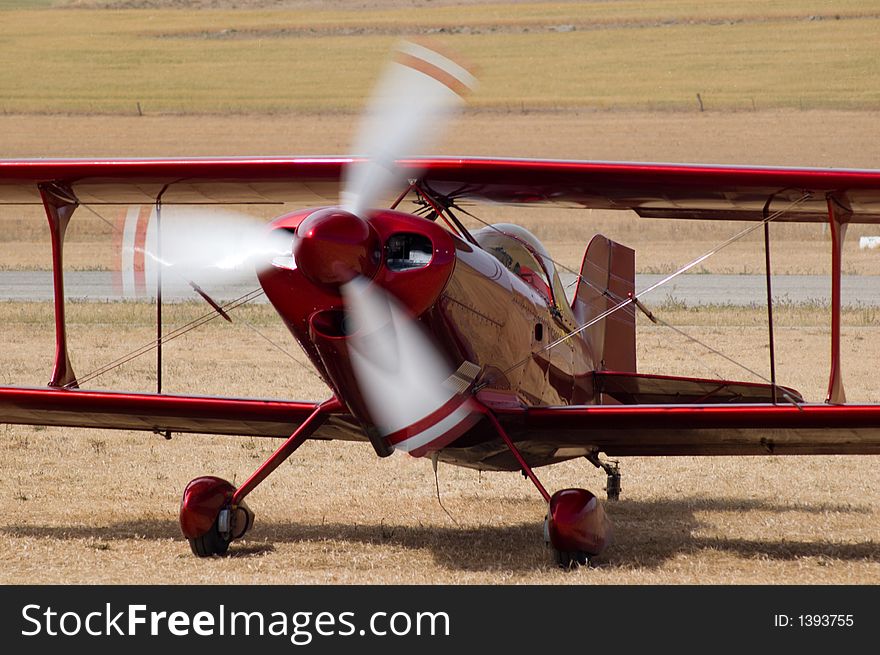 A red biplane at an air show.