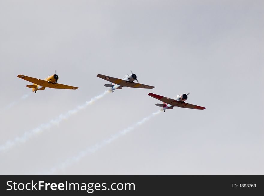 Three Harvard T-6's fly past during an air show. Three Harvard T-6's fly past during an air show.