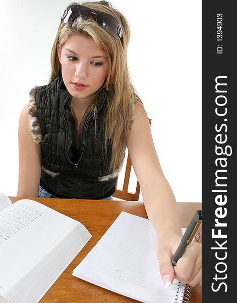 Young woman doing homework at table. Young woman doing homework at table.