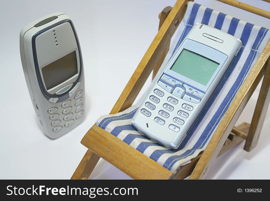 Cell phone in the relaxing chair with blue stripes. Cell phone in the relaxing chair with blue stripes