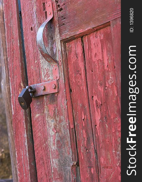 Old red toolshed door locked and rusted
