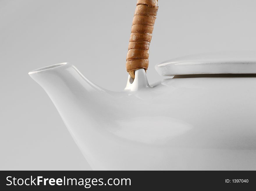 White kettle with straw hand isolated on white close-up