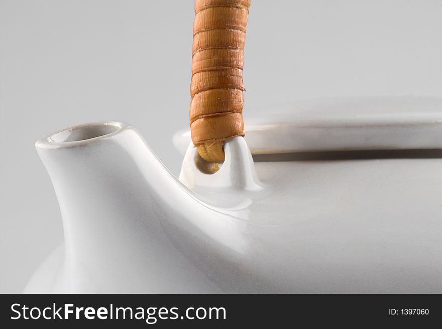 White kettle with straw hand isolated on white close-up
