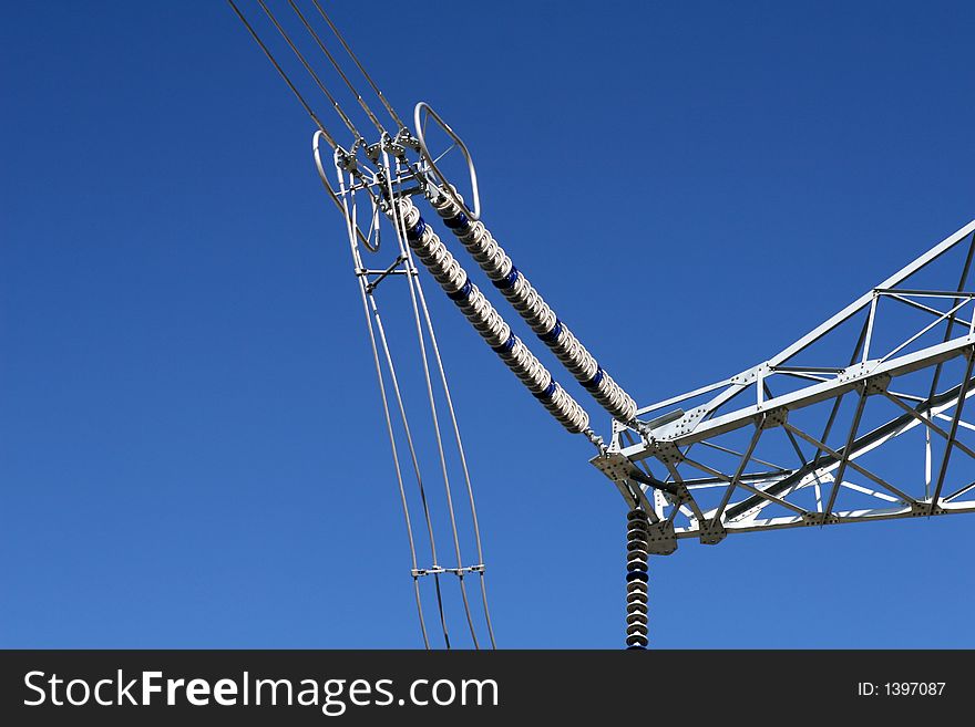 Part of super high voltage power pylon in blue sky.