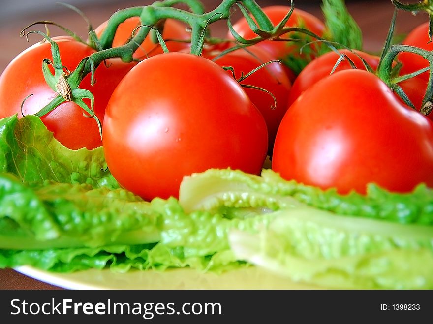 A bunch of lovely red fresh tomatoes in focus. A bunch of lovely red fresh tomatoes in focus