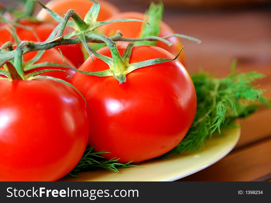 A bunch of lovely red fresh tomatoes in focus. A bunch of lovely red fresh tomatoes in focus