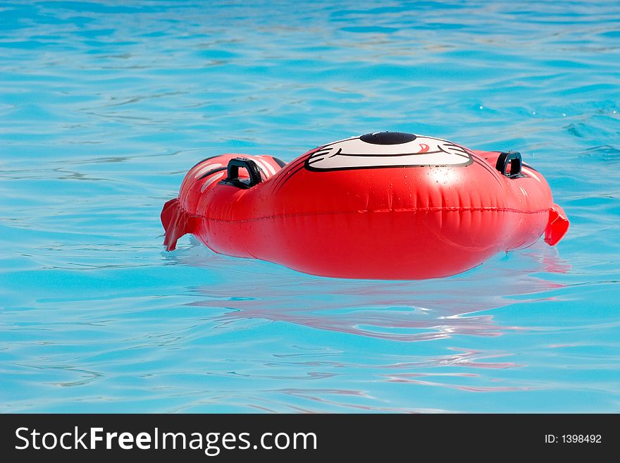 Red rubber ring floating in a swimmin pool. Red rubber ring floating in a swimmin pool