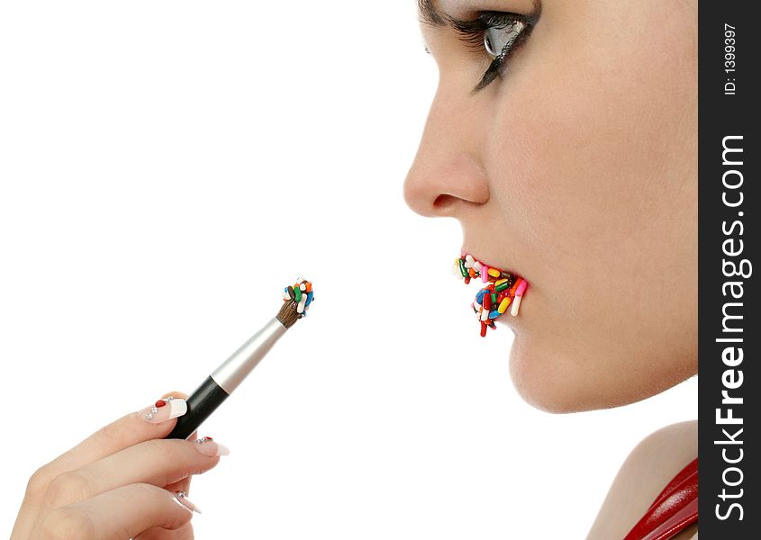 Woman brushing on lipstick made of candy. Focus in mirror. Woman brushing on lipstick made of candy. Focus in mirror.