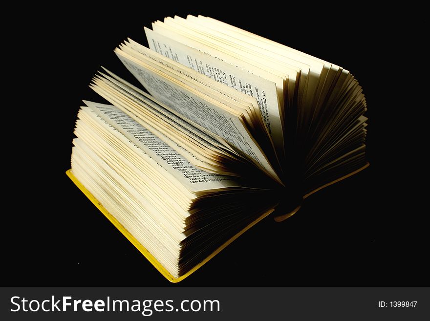Wide opened book in black background.