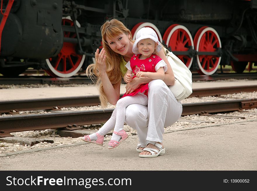 Woman with child beside old locomotive. Woman with child beside old locomotive