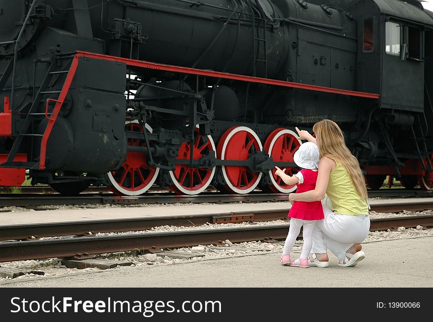 Woman with child beside locomotive. Woman with child beside locomotive