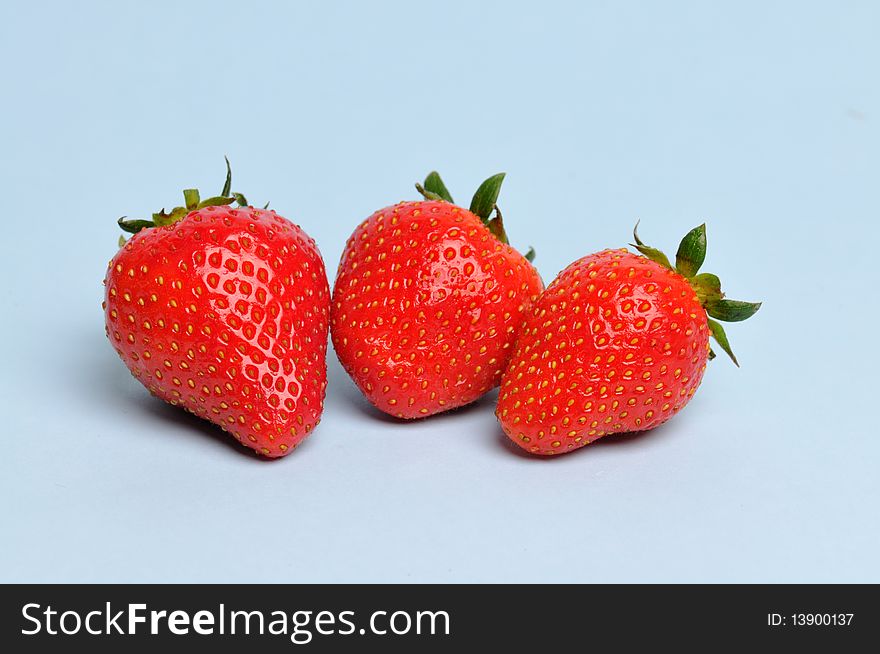 3 red strawberry，Light blue background