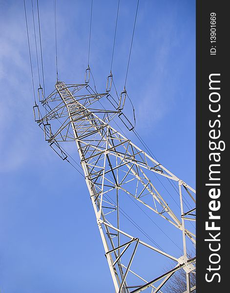 High voltage electrical pylon against blue sky