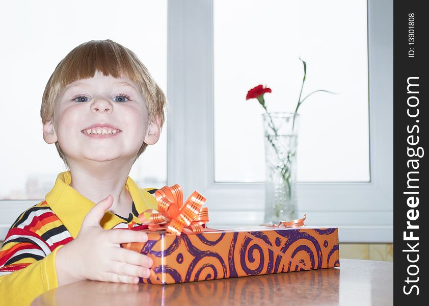 Portrait of the little boy with a gift box on a background. Portrait of the little boy with a gift box on a background
