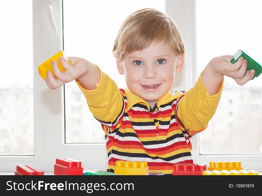 The beautiful little boy poses on a light background. The beautiful little boy poses on a light background
