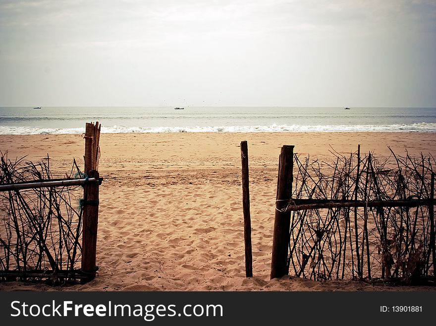 Wooden gate to the sea. Clear beach and still sea.