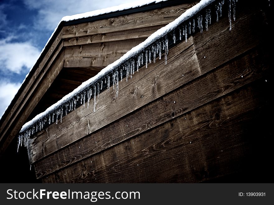 Cabin with icicle's and snow and a dark blue sky. Cabin with icicle's and snow and a dark blue sky