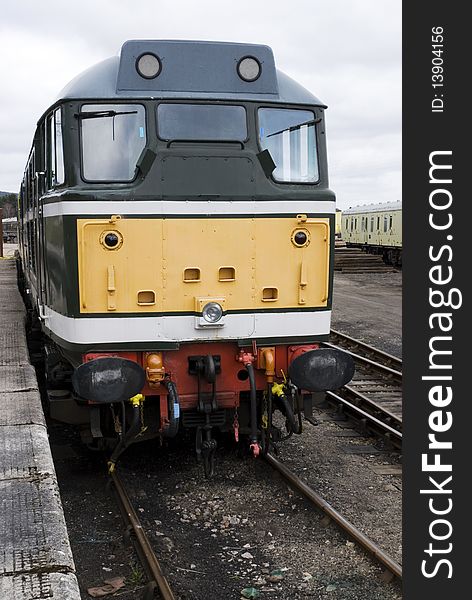 A vertical image of a diesel locomotive engine standing at the platform. A vertical image of a diesel locomotive engine standing at the platform