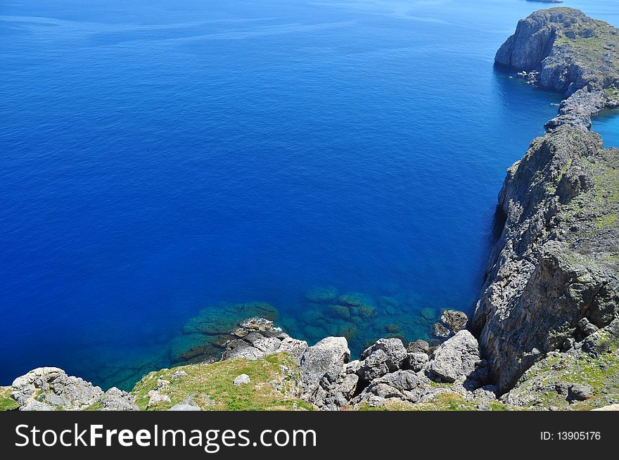 One of the most beautiful places of Rhodes. The beautiful sandy beach, crystal clear sea, blue sky, mountains. One of the most beautiful places of Rhodes. The beautiful sandy beach, crystal clear sea, blue sky, mountains.