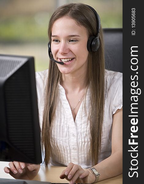 A female employee takes a call at her desk. A female employee takes a call at her desk.