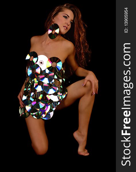 Beautiful girl in a dress from disks on a black background