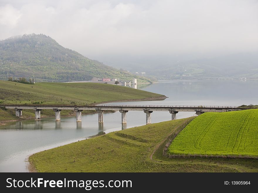 A blue sky with whit clouds and green field, , lake a bridge. A blue sky with whit clouds and green field, , lake a bridge