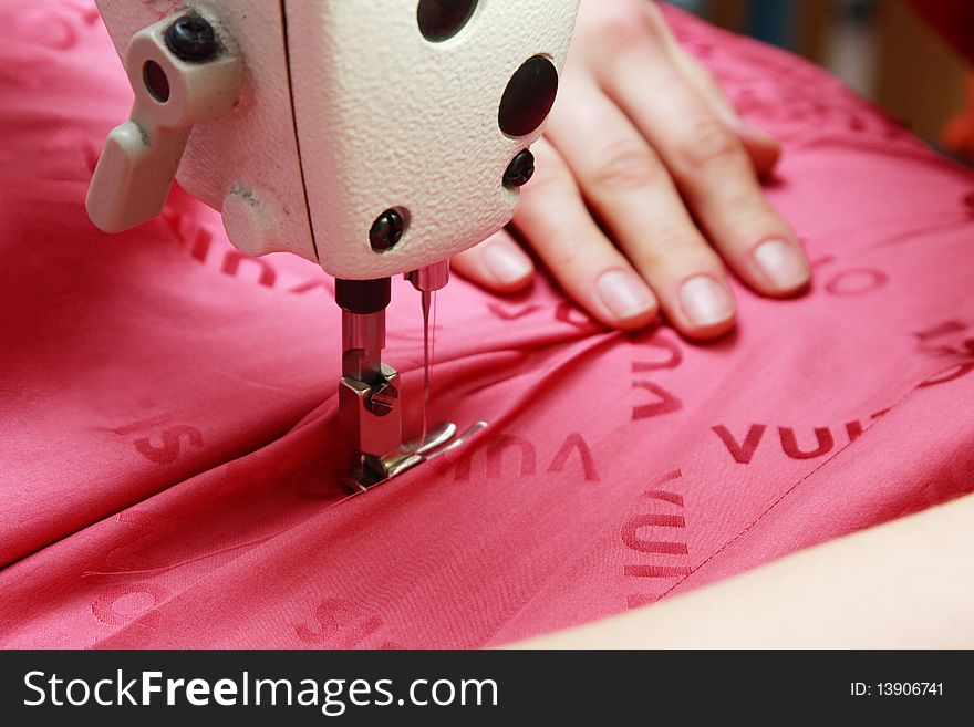 Woman's hand with the help of sewing machine stitch fabric. Woman's hand with the help of sewing machine stitch fabric