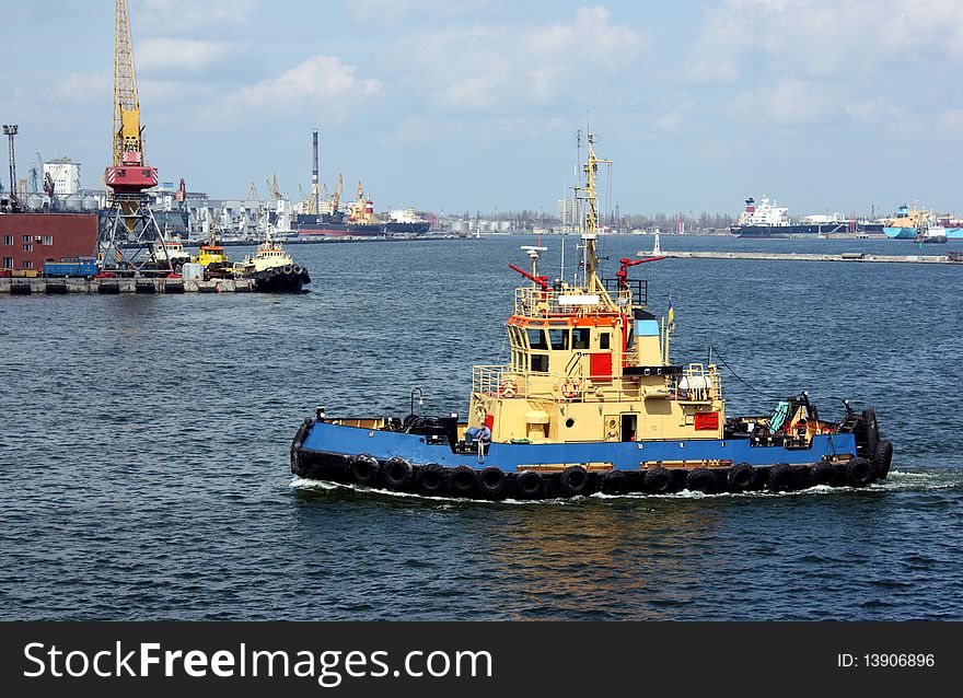 Moving tugboat out at sea with a perfect blur sky.