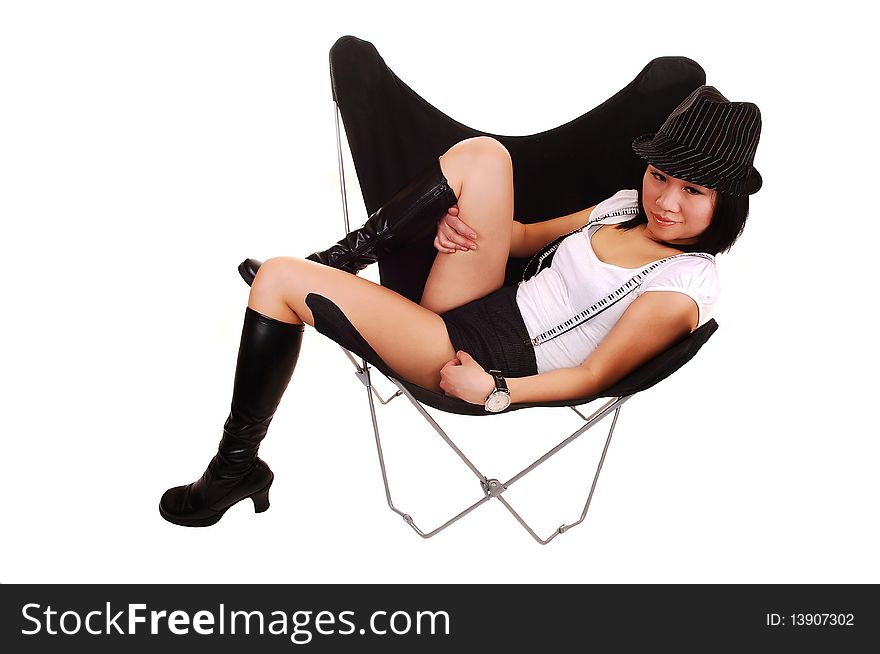 Pretty Chinese woman in shorts, boots and a hat, sitting in a black butterfly chair, showing her nice legs, for white background. Pretty Chinese woman in shorts, boots and a hat, sitting in a black butterfly chair, showing her nice legs, for white background.