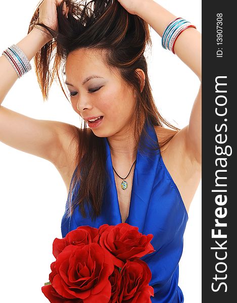 An beautiful young Asian girl, pulling up her hair in the studio in a blue blouse with a bunch of red roses on her lap, over white Background. An beautiful young Asian girl, pulling up her hair in the studio in a blue blouse with a bunch of red roses on her lap, over white Background.