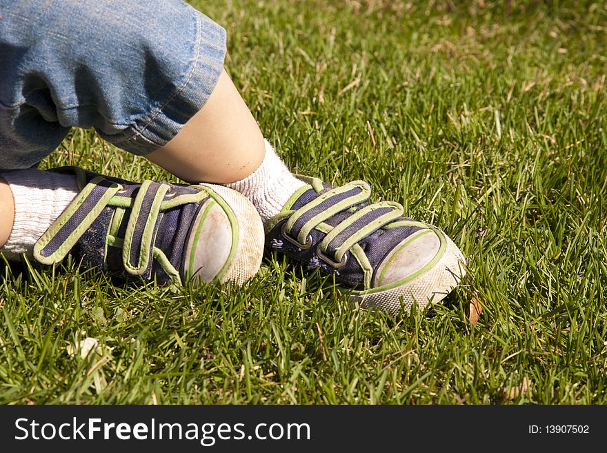 Macro of child's shoes sitting on green grass. Macro of child's shoes sitting on green grass.