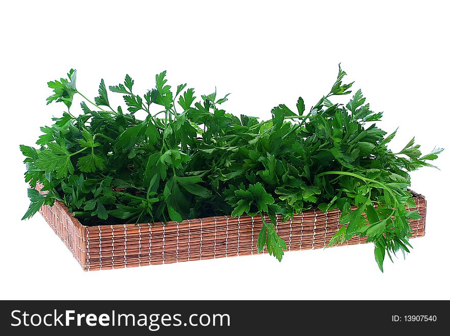 Green leaves of parsley in a wattled flat basket.