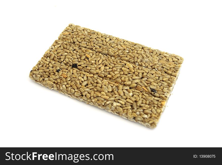 A traidtional oriental delight made from honey and sunflower seeds isolated on a white background. A traidtional oriental delight made from honey and sunflower seeds isolated on a white background