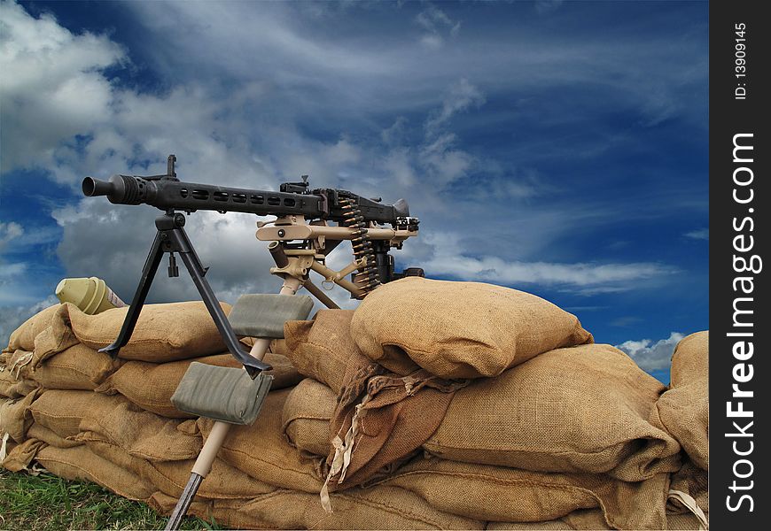 Machine gun on sand bags with threatening sky behind with clipping-path