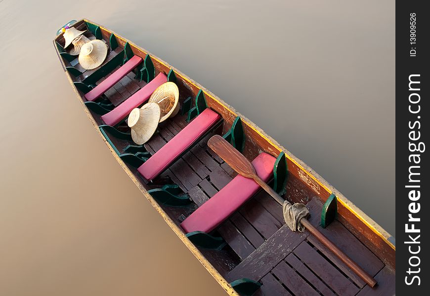 Empty boat floating on the calm river with only hats on it , closeup shot taken from above,SE Asia. Empty boat floating on the calm river with only hats on it , closeup shot taken from above,SE Asia