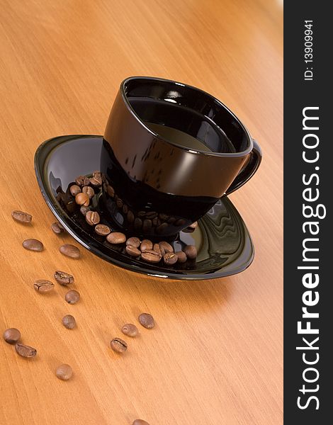 Mug with coffee and beans on the wood table