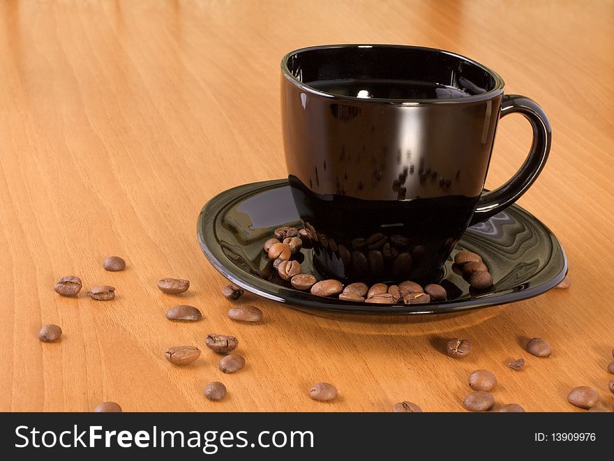 Mug with coffee and beans on the wood table