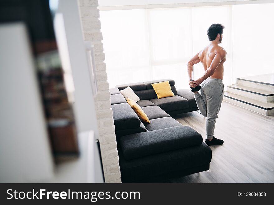 Adult Man Fitness Training At Home Stretching Muscles Before Workout