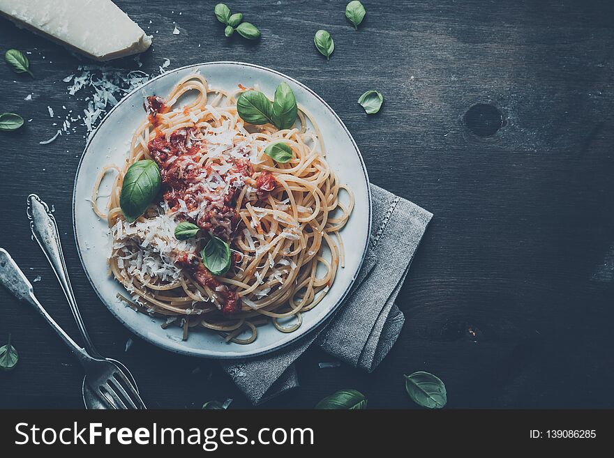 Delicious appetizing classic spaghetti pasta with tomato sauce, parmesan cheese and fresh basil, top view