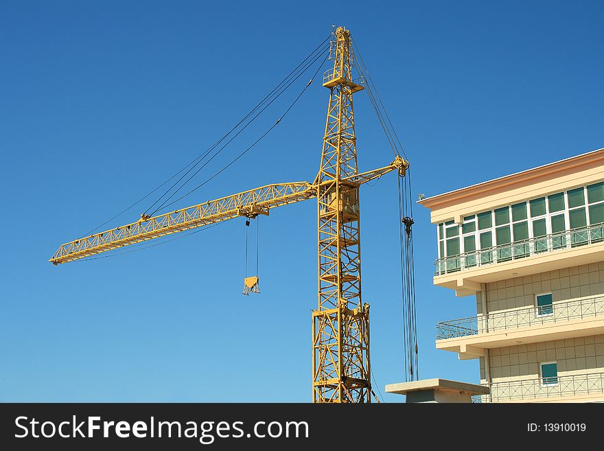 Construction crane against the blue sky. Day. Construction crane against the blue sky. Day.