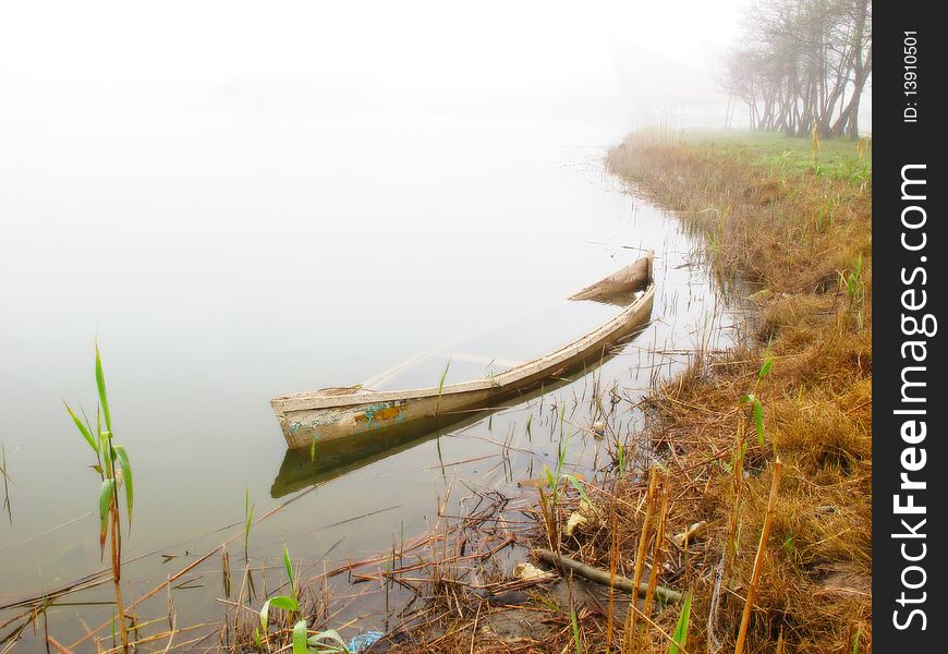 Sunken boat in foggy morning