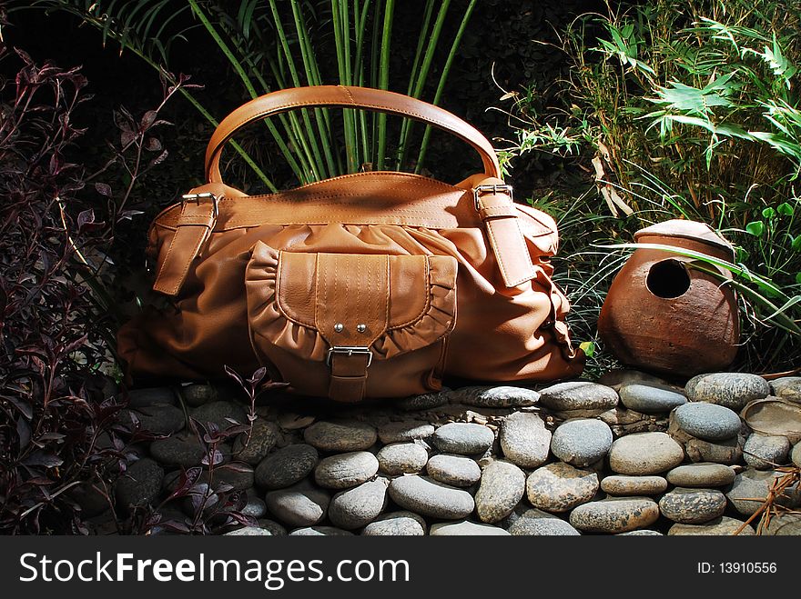 This is a beautiful ladies leather handbag isolated on a beautiful stony background.