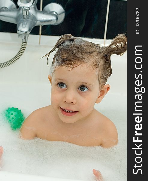 The girl with a soap head in a bath