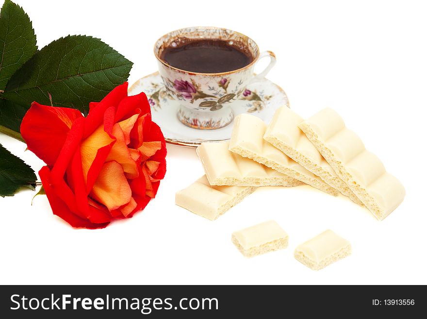 White chocolate, red-yellow rose and a cup of coffee isolated on white, focus on the chocolate in the center. White chocolate, red-yellow rose and a cup of coffee isolated on white, focus on the chocolate in the center
