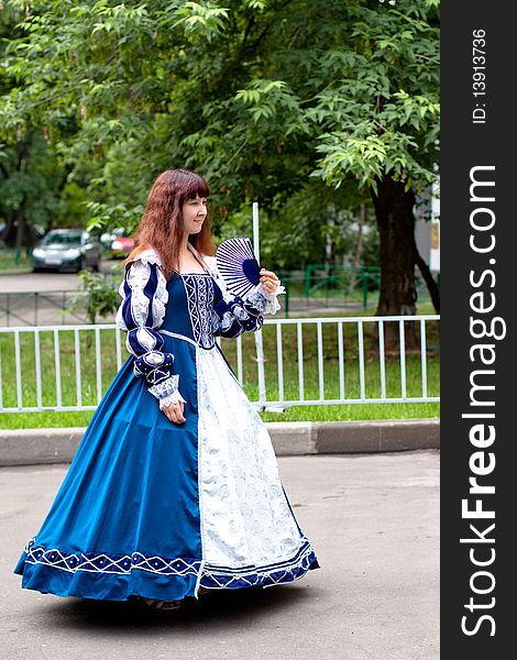 Girl in medieval blue dress in the modern yard. Girl in medieval blue dress in the modern yard