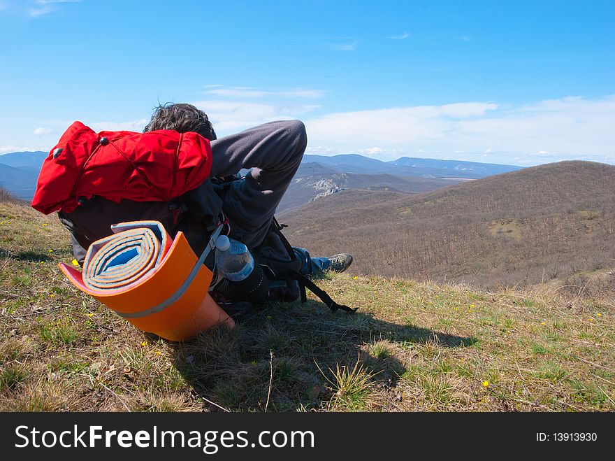 Hiker relaxes on the slope and enjoy the scenery. Hiker relaxes on the slope and enjoy the scenery